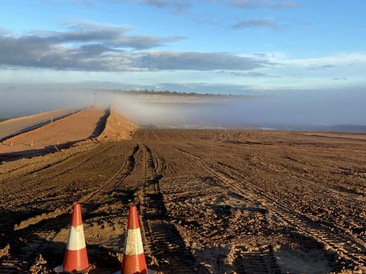 Fog bank rolling over a haul road embankment under construction