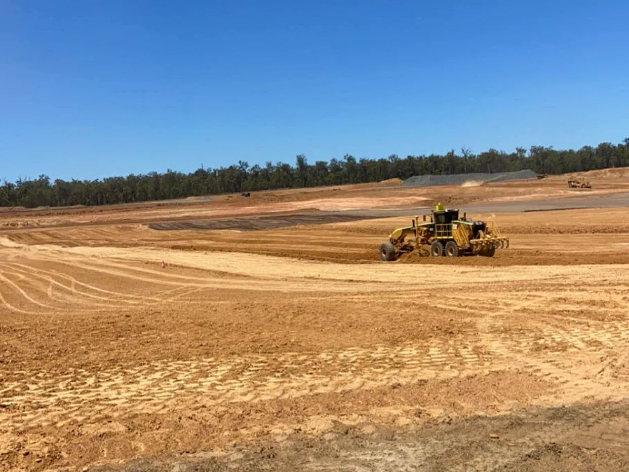 Grader trimming a bulk earthworks pad to design level