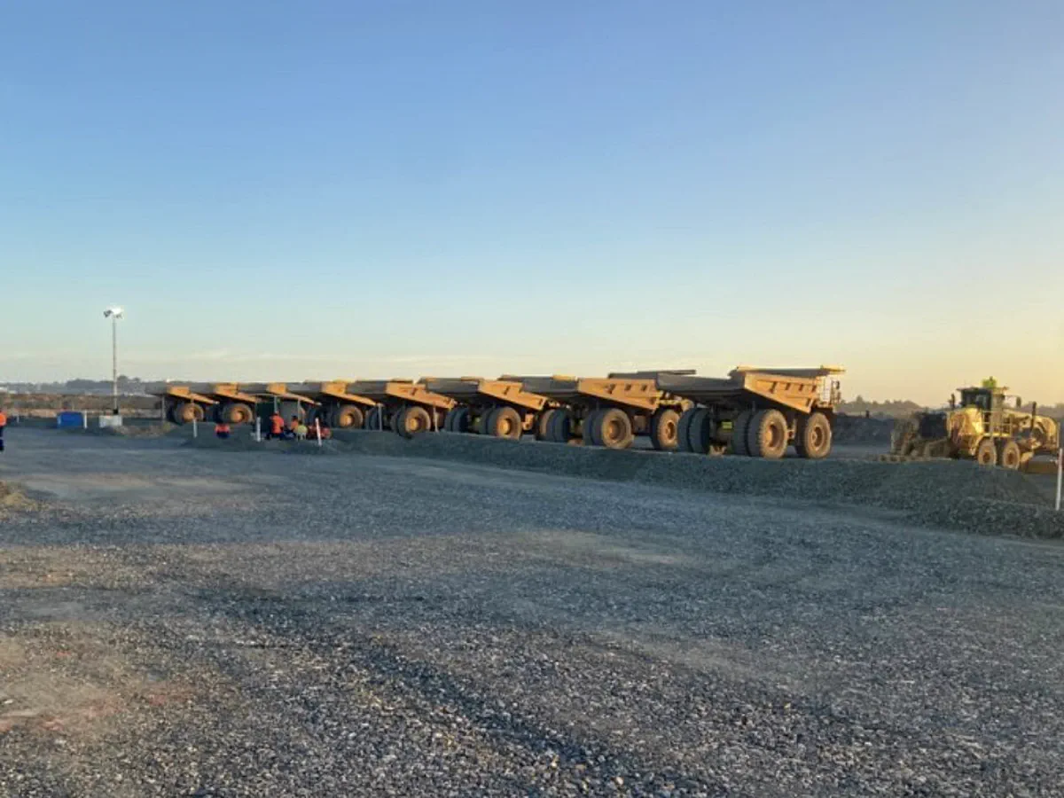 Haul truck fleet lined up at shift change on a WA mine site
